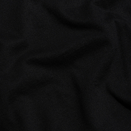 Close-up of soft folds in the black Supima cotton fabric of the Daria Oversized Cropped Tee.