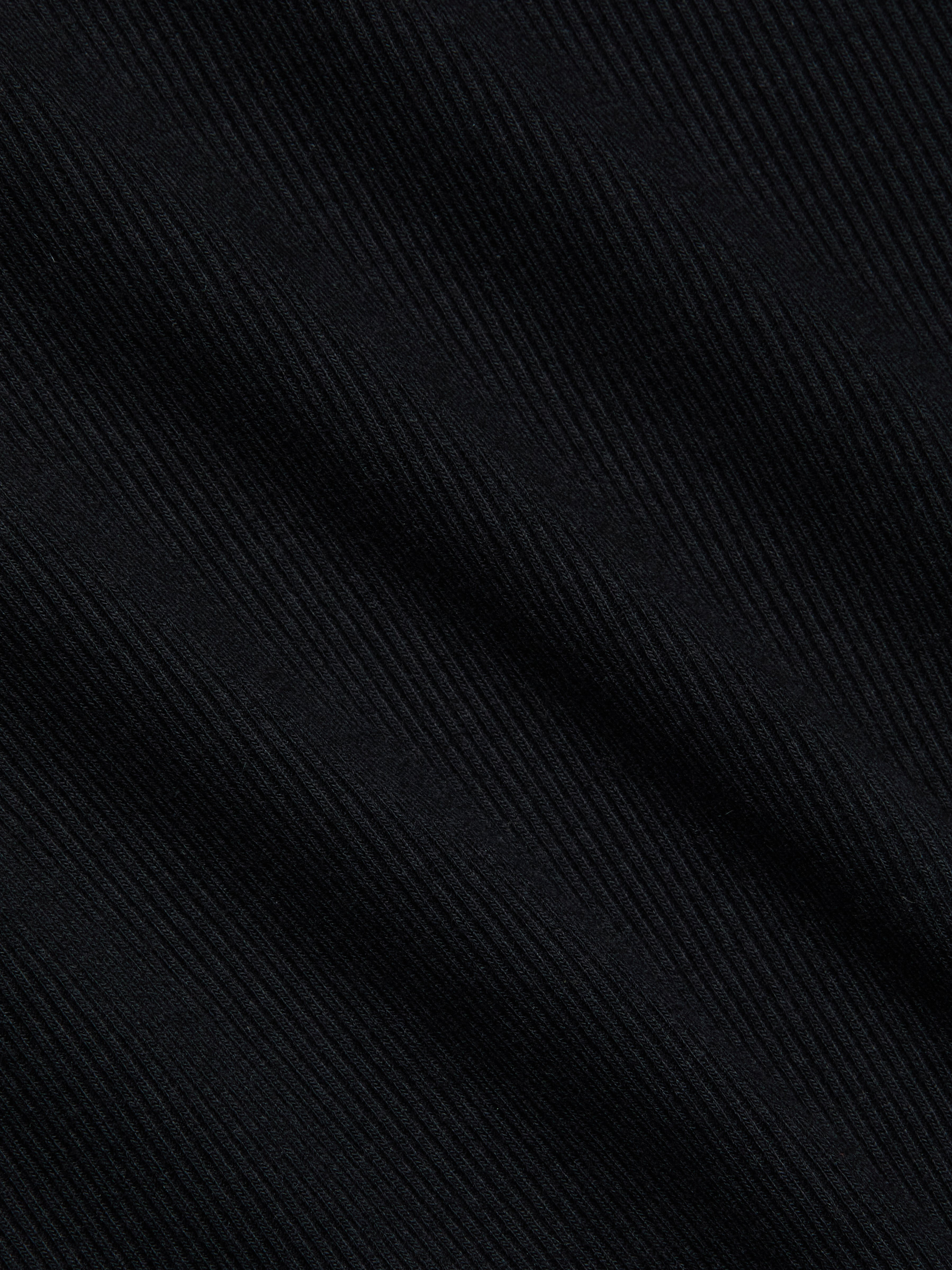Close-up of the Brynlee Scoopneck Tee in black, crafted from stretch cotton ribbed fabric with diagonal textured lines that form a subtle striped pattern and offer a soft, slightly glossy finish.