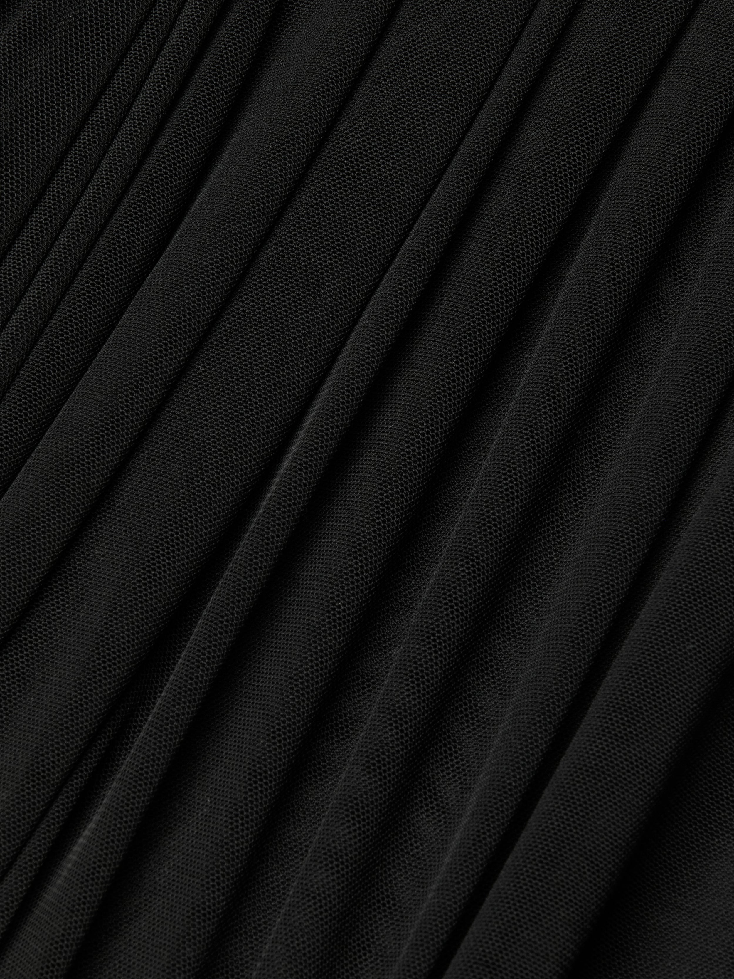 Close-up of the Poppie Off-The-Shoulder Bodysuit in black, featuring finely pleated fabric with a subtle stretch mesh texture and diagonal, evenly spaced folds for a sleek, sculpted look.