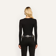 Back view of a person wearing a long-sleeved black Elara Scoopneck Bodysuit with black jeans and an ornate silver-buckle belt.