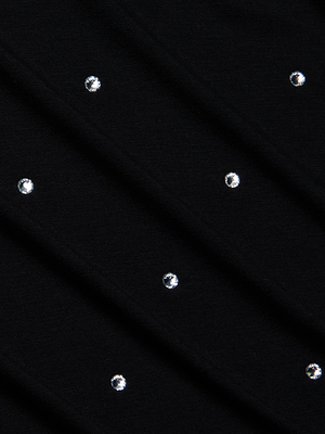 A close-up of the Stormy Embellished Tee by L'AGENCE shows black stretch rayon jersey fabric adorned with small, evenly spaced round silver studs for a subtle, decorative look—ideal for a chic, crystal-embellished cropped tee style.