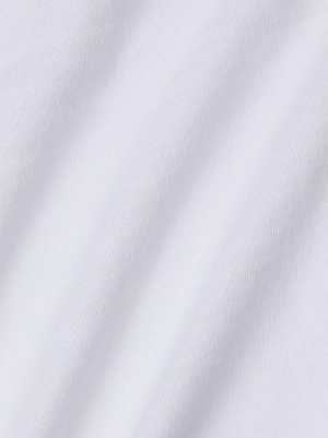 Close-up of the Stormy Cropped Cotton Tee shows white organic cotton fabric with soft, diagonal folds and a subtle ribbed texture, casting gentle shadows across its semi-relaxed fit.