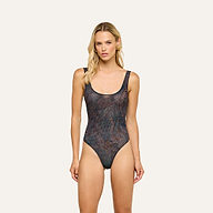 Woman with long blonde hair wearing the Kalea Mesh Bodysuit in midnight blue paisley stands facing forward against a plain light background.