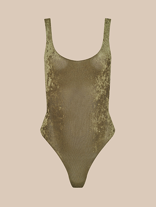 The Kalea Velvet Bodysuit, featuring a luxe gold hue, scoop neckline, and high-cut legs, is showcased against a plain beige background.