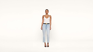 A woman stands facing forward against a plain white background, wearing a white tank top, light blue jeans, black belt, and black high-heeled shoes.