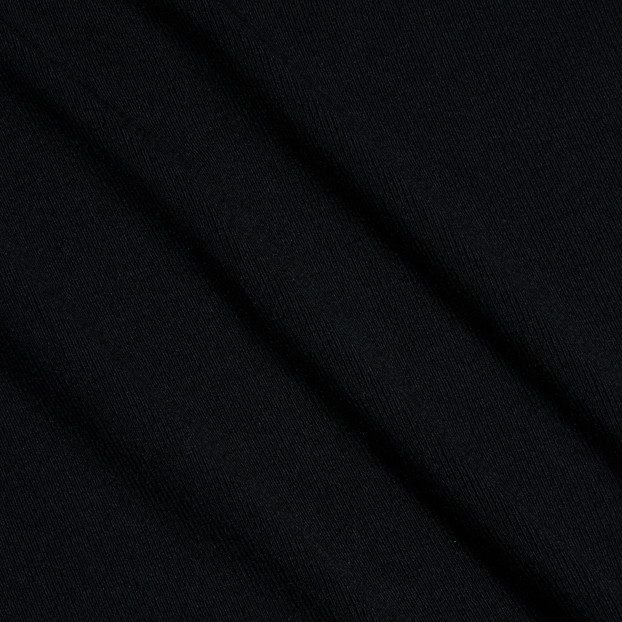 Close-up of black ribbed knit fabric seen at a diagonal angle, highlighting its subtle texture and fine parallel lines across the surface—the perfect choice for the Shania Racerback Tank.