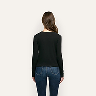 Back view of a person wearing a black organic cotton Leanne Cotton Tee and blue jeans.
