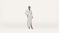 A woman stands confidently wearing a light-colored, long-sleeve wrap dress with a waist tie and slit, paired with heeled sandals, against a plain white background.