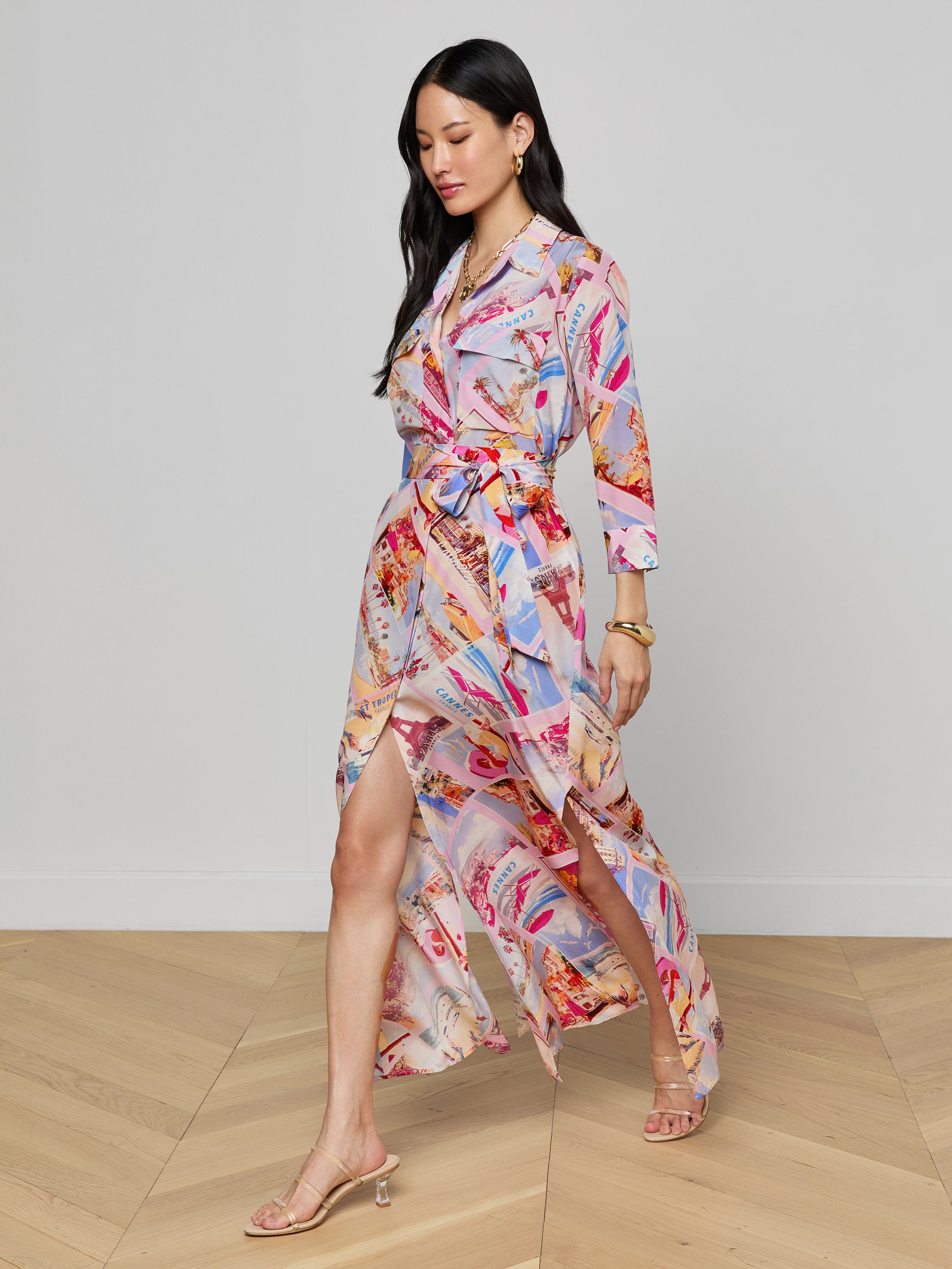 A woman wearing the Cameron Silk Shirt Dress and heeled sandals walks confidently against a plain white background.