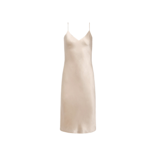 The Jodie Silk Slip Dress is a champagne-hued satin knee-length slip dress designed with delicate spaghetti straps, a flattering V-neckline, and an elegant bias cut, shown against a plain white background.