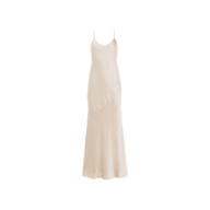 The Serita Silk Gown is a sleeveless, ankle-length slip dress crafted from luxurious champagne silk charmeuse, featuring delicate spaghetti straps and shown against a white background.