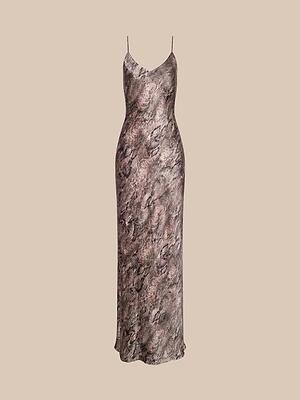 The Serita Silk Gown is a long, sleeveless dress with thin spaghetti straps and a chic brown and black snake print—perfect as a wedding guest outfit, shown on a beige background.