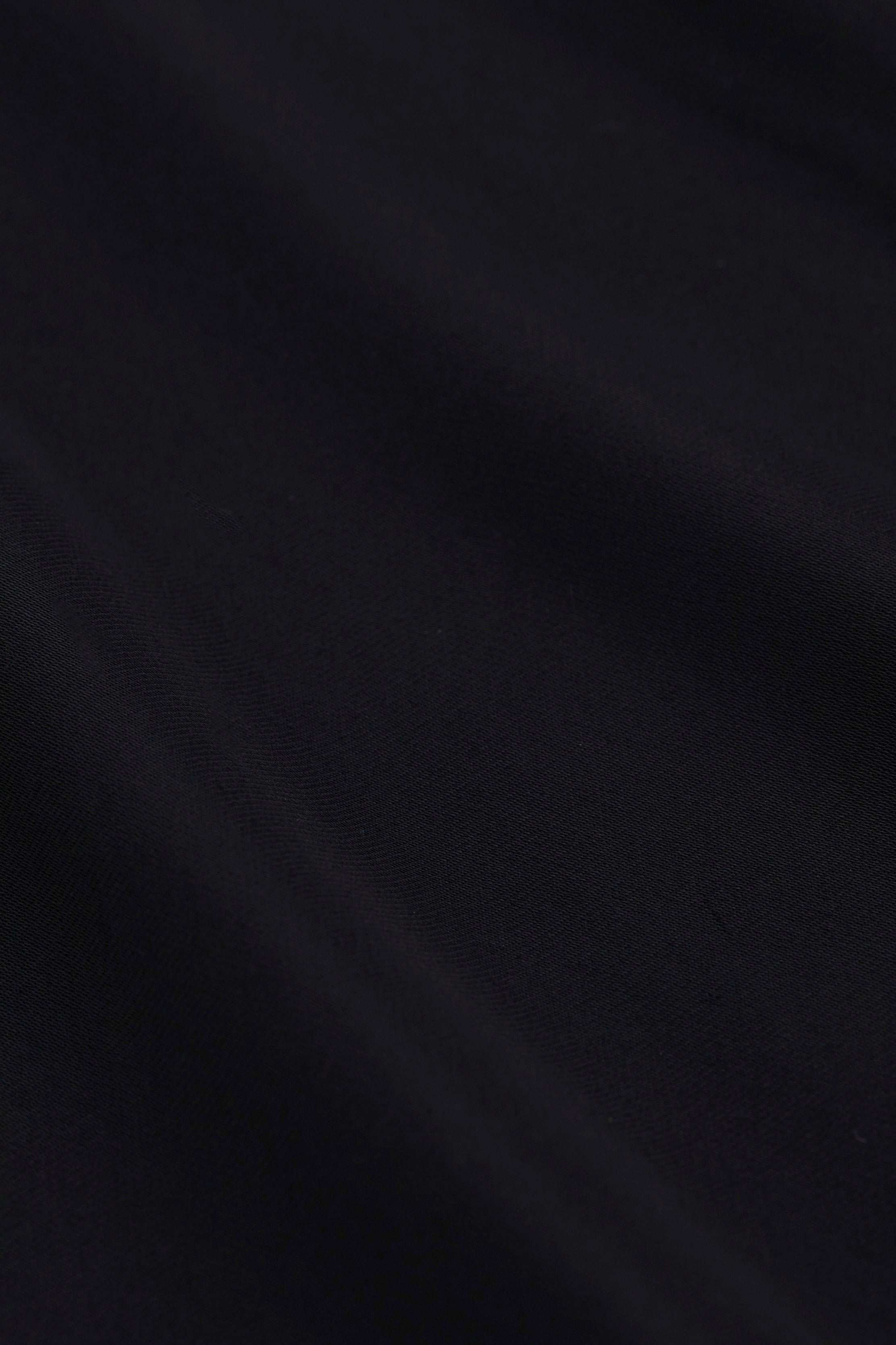 A close-up of the Akiya Satin Maxi Dress in black, highlighting its textured satin fabric and subtle diagonal folds.