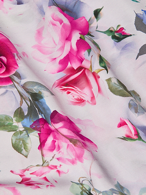 A close-up of smooth bias-cut satin with pink roses, green leaves, and delicate stems on a light background—ideal for the elegant Akiya Satin Maxi Dress.