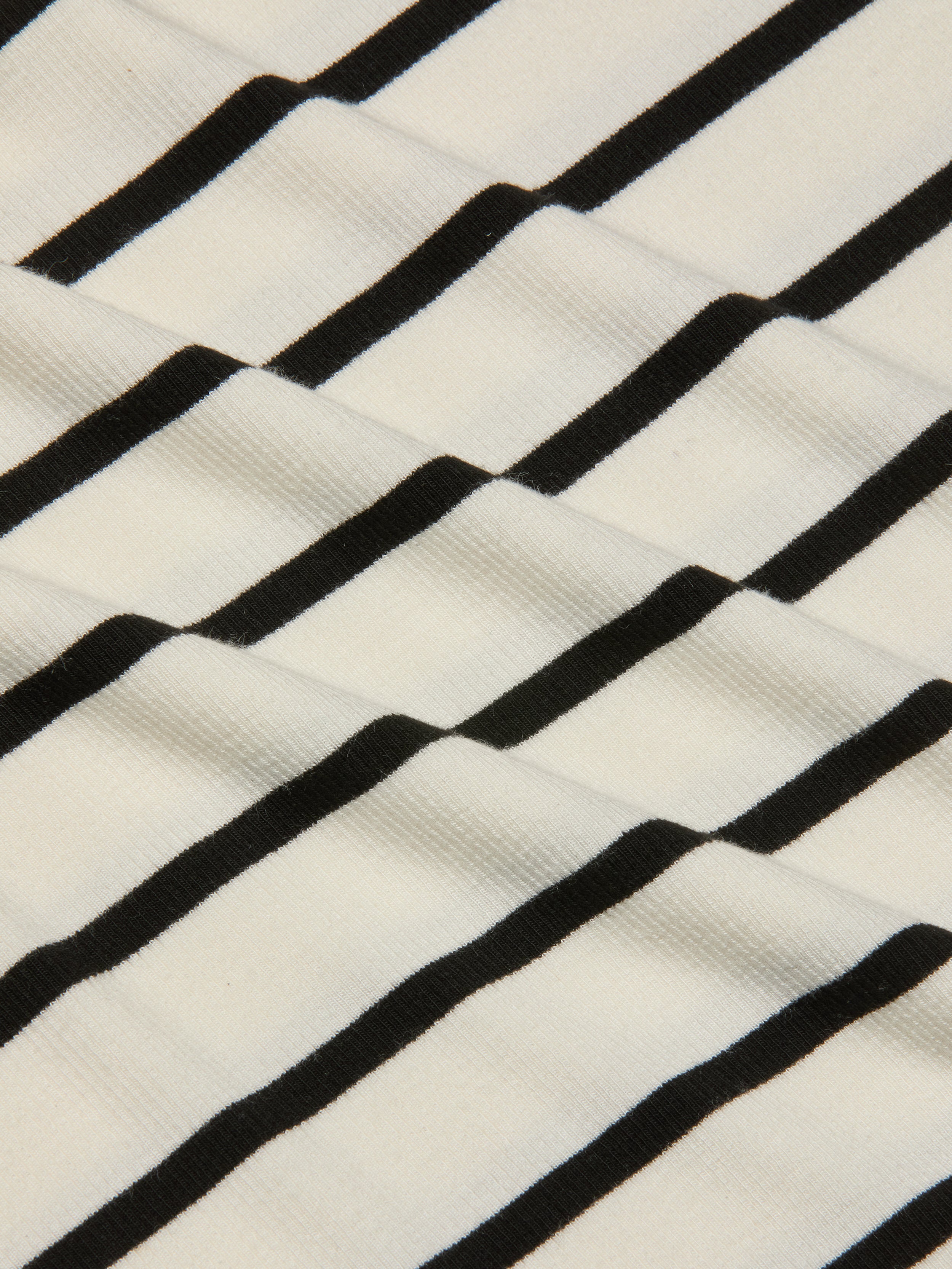 Close-up of the Nura Racerback Midi Dress fabric, featuring black horizontal stripes on a white background that create a wavy, textured pattern.