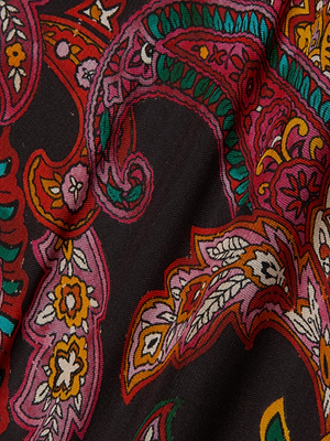 A close-up of dark fabric with a vibrant paisley print in red, pink, green, orange, and white. Soft folds and swirling details make this material ideal for the Susanna Silk Lace Gown by L'AGENCE.