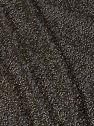 Close-up of the Inori Beaded Mini Dress, featuring a densely embroidered surface with metallic beads in black, creating a textured and shimmering effect; a diagonal seam is visible through the intricate pattern.