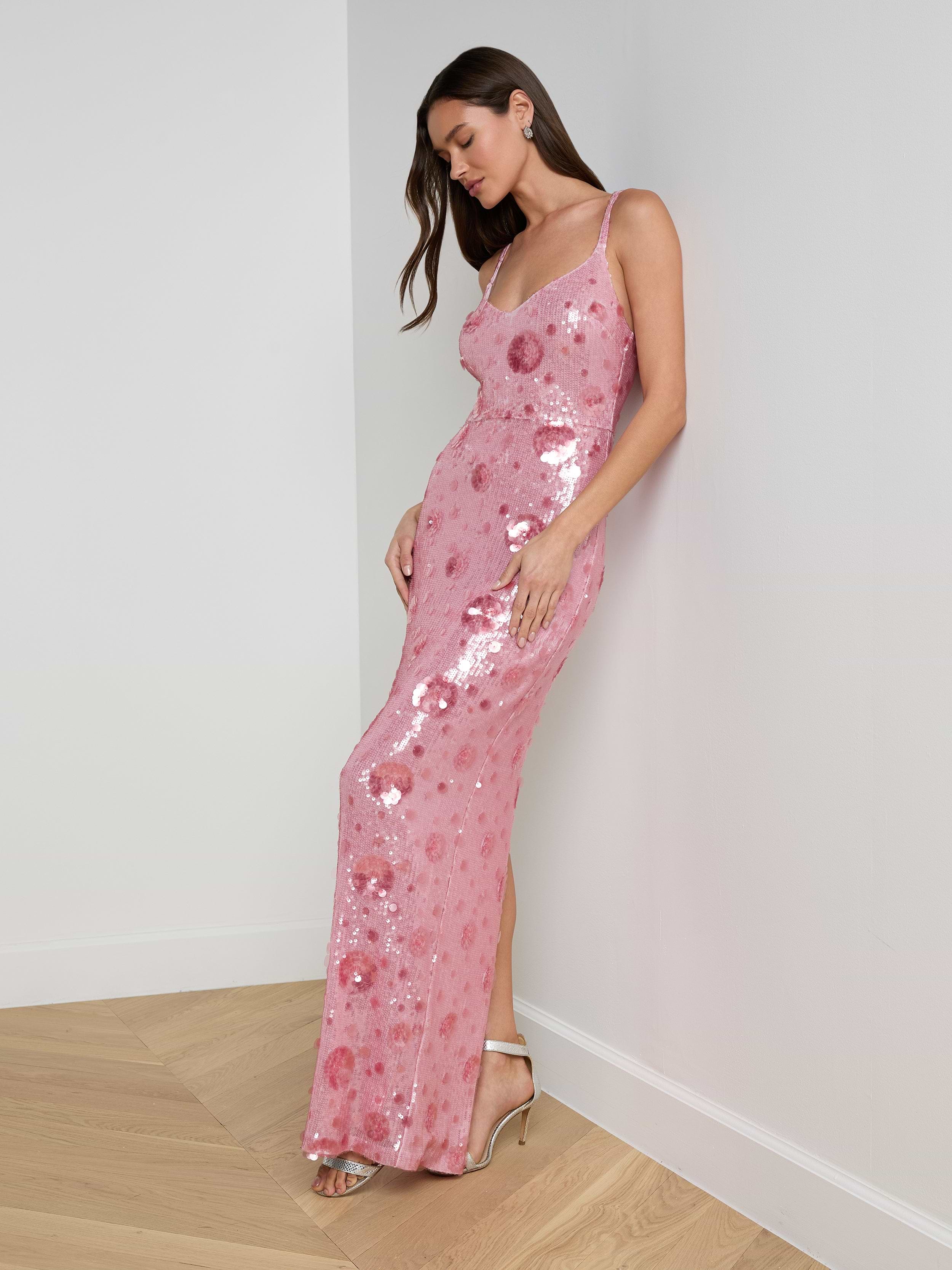 A woman wearing the Karma Sequin Maxi Dress and high heels stands against a white background, looking downward with one hand on her hip.