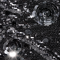 Black sequin fabric of the Karma Sequin Maxi Dress featuring two large, three-dimensional sequin flower appliqués.