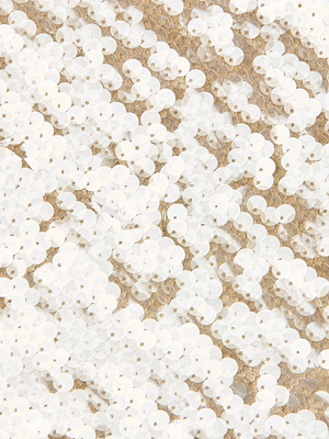 Close-up of overlapping white sequins sewn onto beige fabric on the Karma Sequin Maxi Dress, creating a shiny, textured surface inspired by NYFW runway styles.