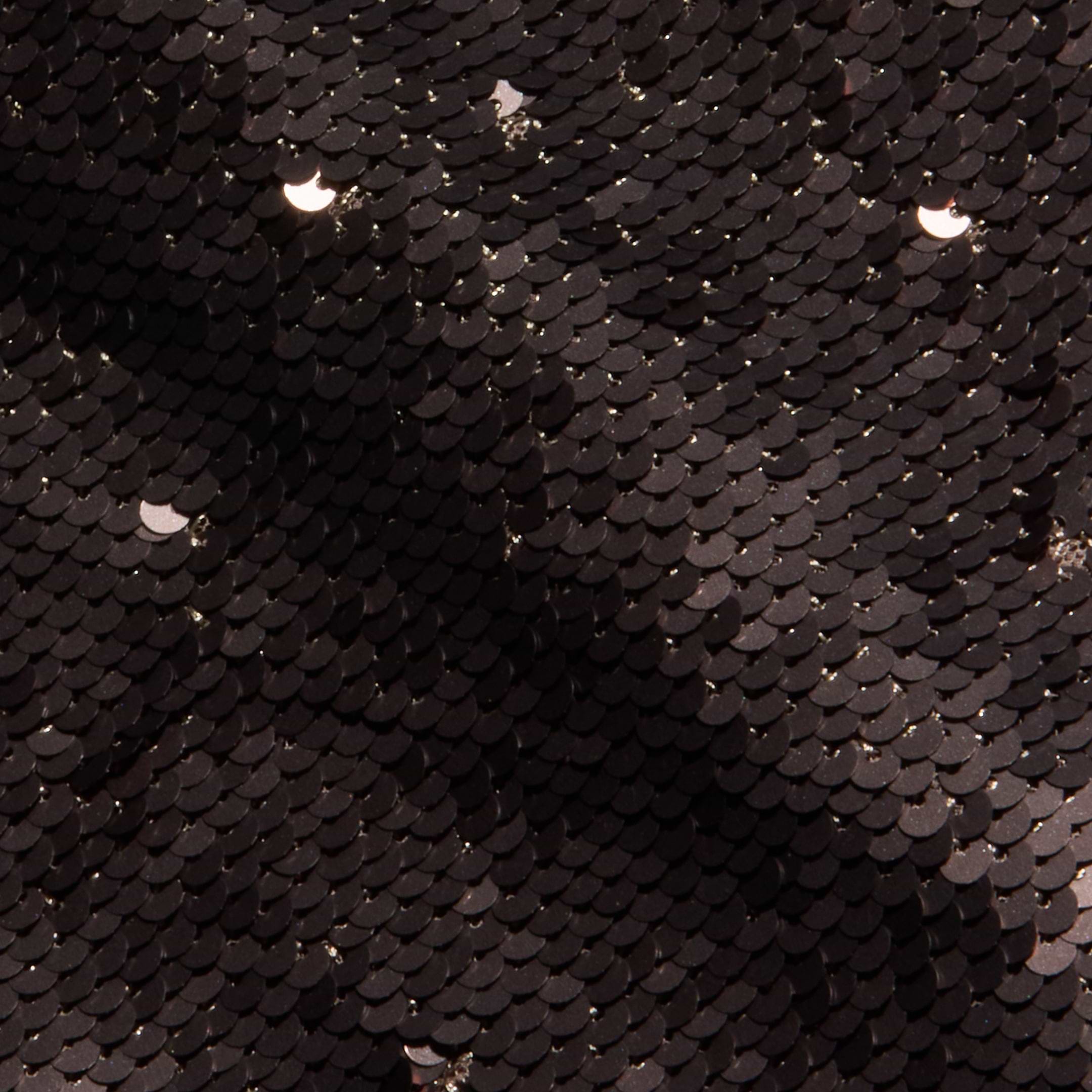 Close-up of glossy, overlapping black sequins on the fitted Karma Sequin Maxi Dress, with scattered crescent-shaped light reflections highlighting the textured surface.