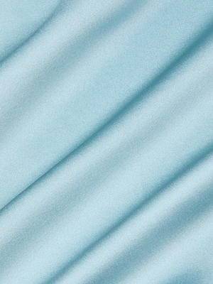 A close-up of smooth, light blue fabric with gentle diagonal folds and soft shadows—ideal for the Charmaine Silk Gown, perfect for formal occasions.