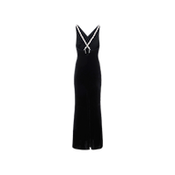 The Saint Velvet Gown is a sleeveless black velvet dress with a V-neckline, white trim, and a small white bow at the center. Its fitted silhouette flares gently at the hem for an elegant look.