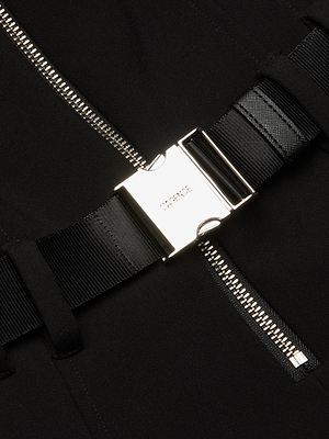 Close-up of the Kylo Shirt Dress, a black structured suit dress featuring silver zippers and a metallic engraved buckle on a black strap, adding a sleek, modern touch to this stylish ensemble.