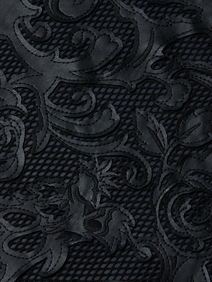 Close-up of the Kazuko Vegan Leather Dress featuring black lace with an intricate laser-cut floral pattern over a mesh background for a textured, decorative look.