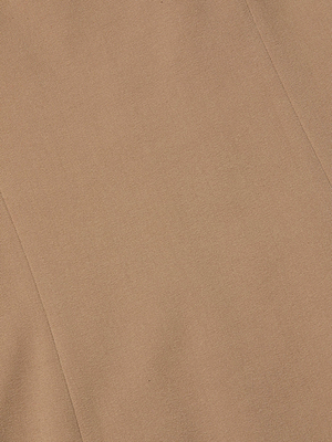Close-up of the Jettie Mini Dress by L'AGENCE, featuring light brown stretch suiting fabric with a subtle diagonal seam and a fine, smooth texture.