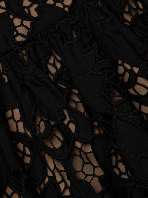 Close-up of the Flyn Lace Midi Dress by L'AGENCE Sale, featuring intricate black floral eyelet lace over a beige background for a striking contrast between delicate lace and underlying fabric.