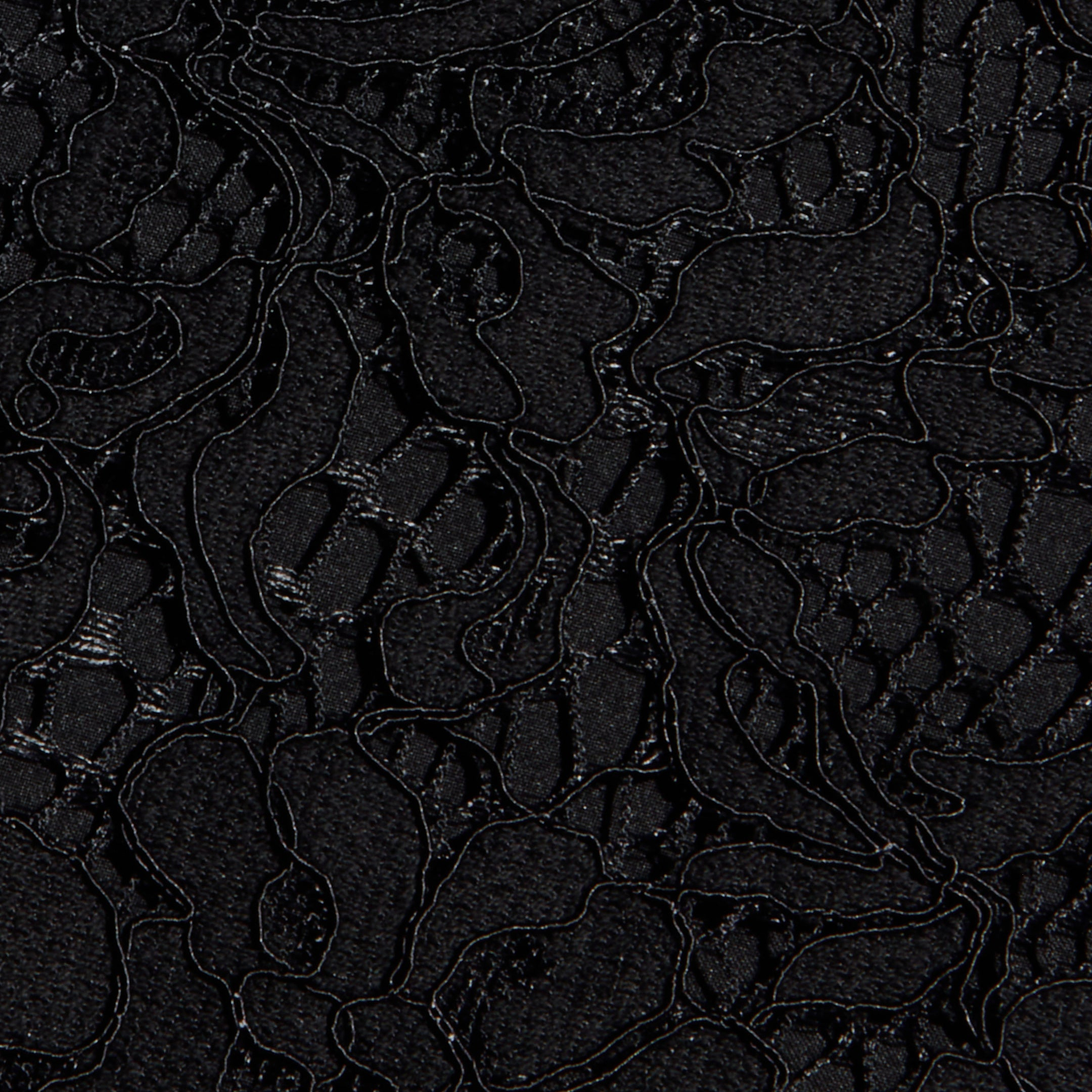 Close-up of the Sutton Lace Maxi Dress in black, featuring intricate floral lace fabric with delicate, swirling embroidered lines and sheer, textured areas that highlight its elegant pattern.