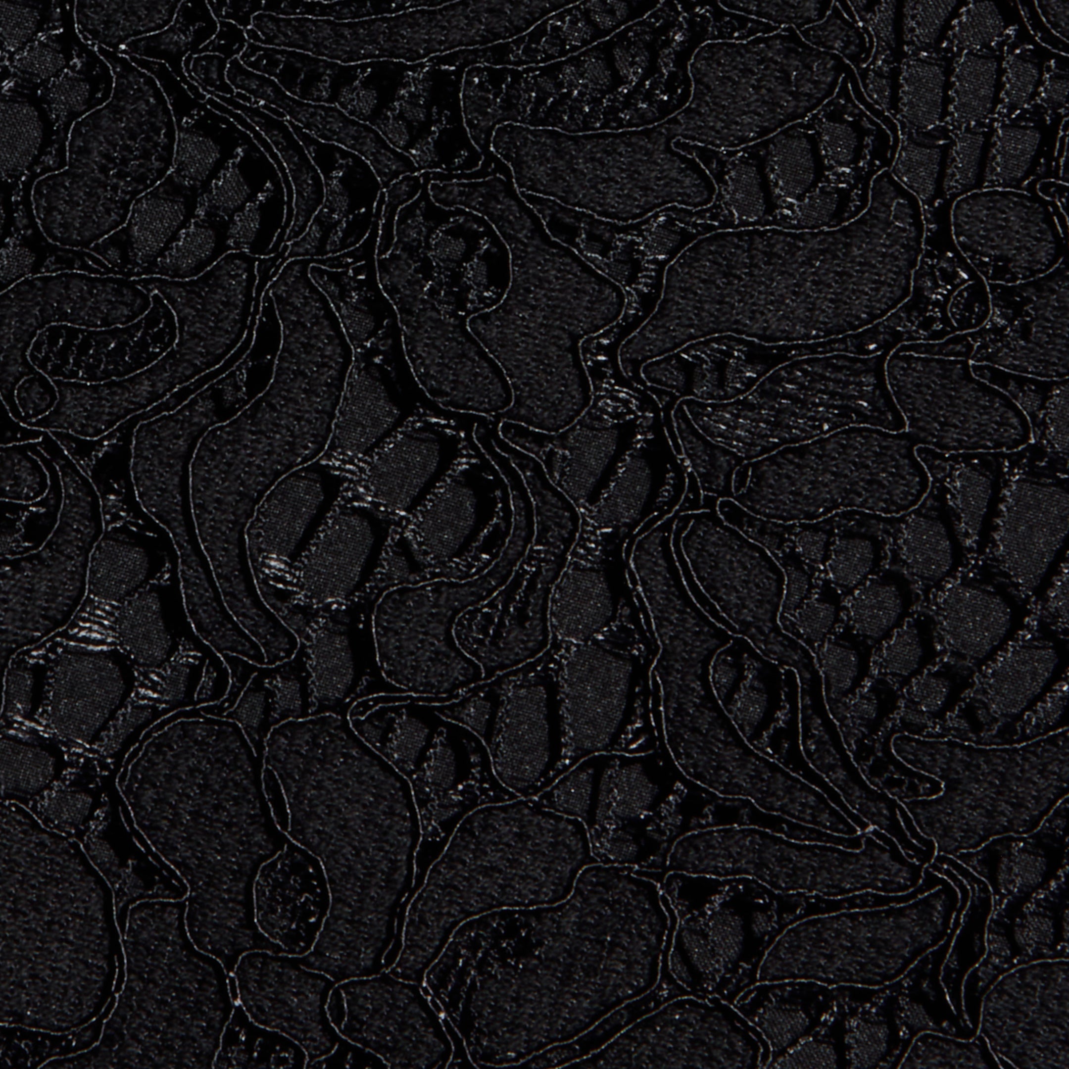 Close-up of the Sutton Lace Maxi Dress in black, featuring intricate floral lace fabric with delicate, swirling embroidered lines and sheer, textured areas that highlight its elegant pattern.