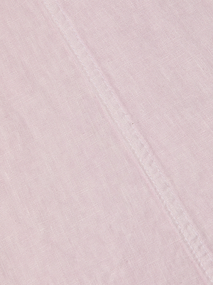 Close-up of the Mitzy Linen Midi Dress in light pink, showing textured weave and a visible diagonal seam. Detailed stitching runs across the fabric, highlighting the dresss fiber quality and precise seam construction.