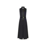 The Kolton Dress is a sleeveless, black cotton-blend midi dress with a collared neckline and front zipper closure. It features a fitted bodice, flared skirt, and a matching black belt at the waist. Shown against a plain white background, this dress highlights its center zip design.