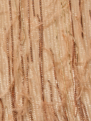 Close-up of the Prince Dress’s beige fabric featuring vertical rows of shiny bronze and gold sequins, thin wispy threads, and delicate crystal chain fringe for a shimmering, textured effect.