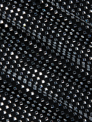 Close-up of the Harlynn Crystal Mini Dress: black fabric ripples with a grid of sparkling, square silver studs, evoking the glamour and shine of a party-ready mini dress.