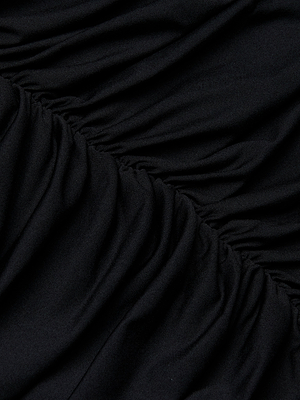 Close-up of Cheryl Shirred Midi Dress in black stretch jersey, featuring gathered, ruched texture that creates curved, rippled lines and folds for a flattering figure.
