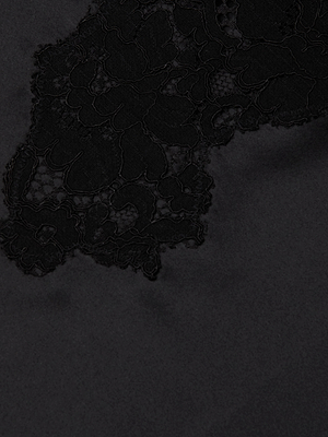 Close-up of the Fenna Silk Lace Dress by L'AGENCE, showcasing intricate floral lace and delicate embroidery on a matte black background—its sheer texture adds striking contrast, ideal for a standout bustier top or silk charmeuse dress.