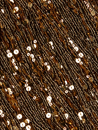 Close-up of the Noella Sequin Fringe Dress, featuring gold sequins and beads shimmering on fabric in dense, wavy horizontal patterns with fringe embellishments, creating a rich, textured, and reflective surface.