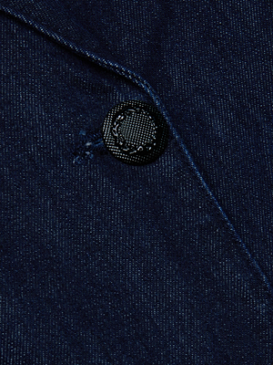 Close-up of the Kylan Blazer Dress by L'AGENCE showcases indigo denim fabric with a black button, highlighting texture and stitching details—ideal for creating a polished mini blazer dress or elevated power suit look.