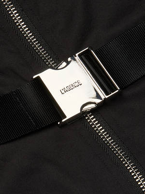 A shiny silver buckle clasp engraved with LAGENCE, attached to a black strap over stretch poplin fabric and a silver zipper, adds a chic detail to the Rima Maxi Dress—perfect for elevating your black dress style.