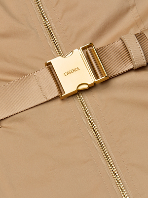 Close-up of the Rima Maxi Dress in neutral tan stretch poplin, featuring a gold zipper and a matching gold LAGENCE buckle on its coordinating belt.