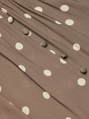 Close-up of the Rosette Maxi Dress featuring brown fabric with white polka dots, fabric-covered buttons in a row, and gathered pleats that highlight its summer-ready style.