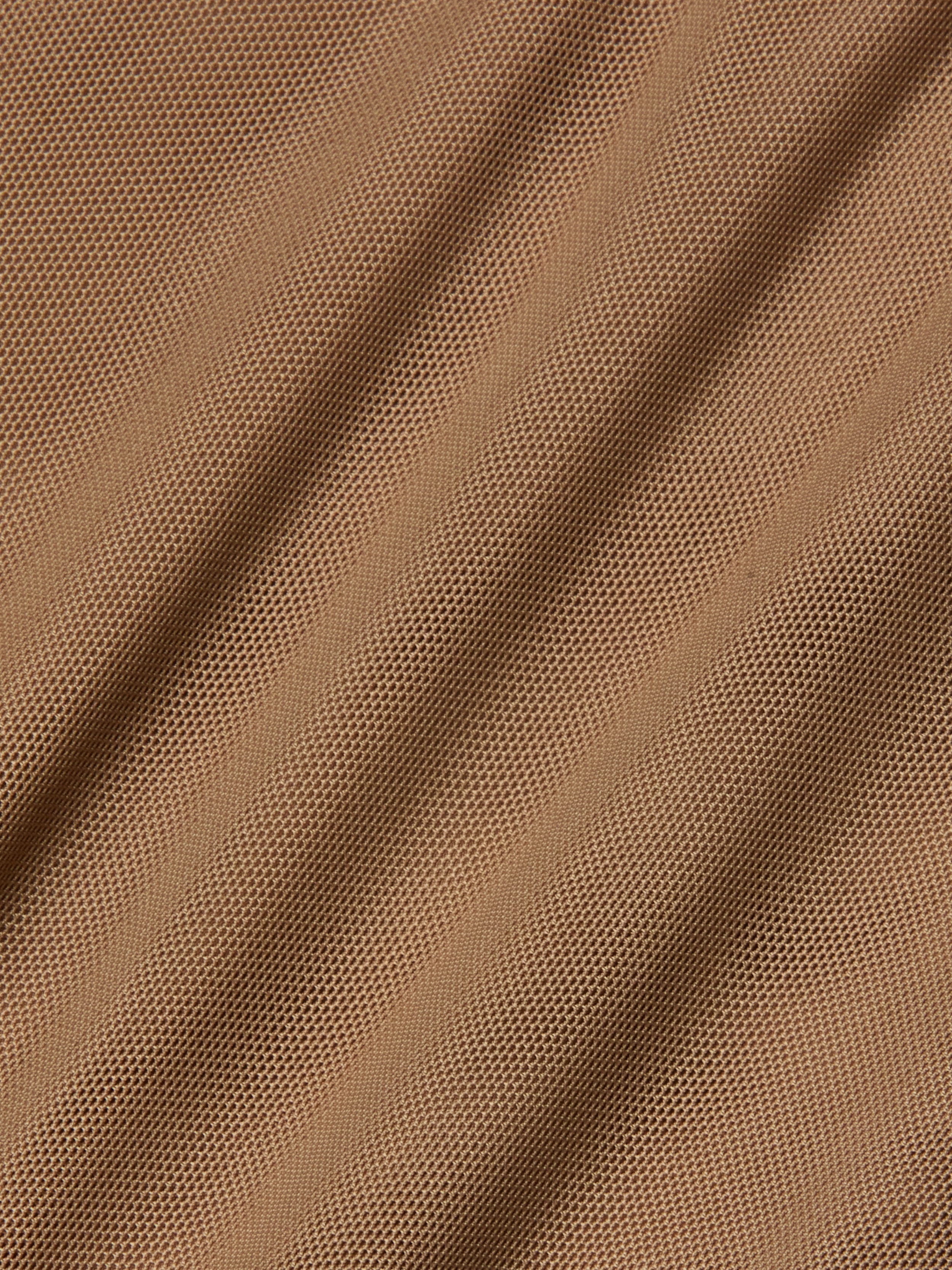 Close-up of light brown stretch mesh fabric with diagonal folds and visible small holes, creating a textured and patterned surface often used as bodysuit lining for garments like the Sorella Mesh Midi Dress.