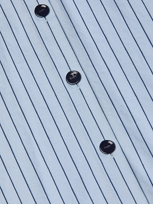Close-up of the Ralphie Midi Dresss light blue Italian poplin fabric with dark vertical pinstripes and four black buttons in a row—details showcasing this refined striped shirt dress.