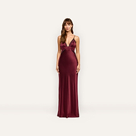 A woman wearing the Elsa Silk Gown, a floor-length, deep red silk slip dress with black lace accents at the neckline and waist.
