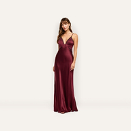 A woman wearing an Elsa Silk Gown, a floor-length, deep red silk slip dress with a V-neckline and delicate lace accents.