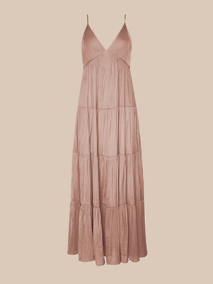 La robe longue à volants Lua est une robe longue sans manches en satin rose fush, avec de fines bretelles spaghetti réglables et une jupe fluide à volants, présentée sur un fond beige.