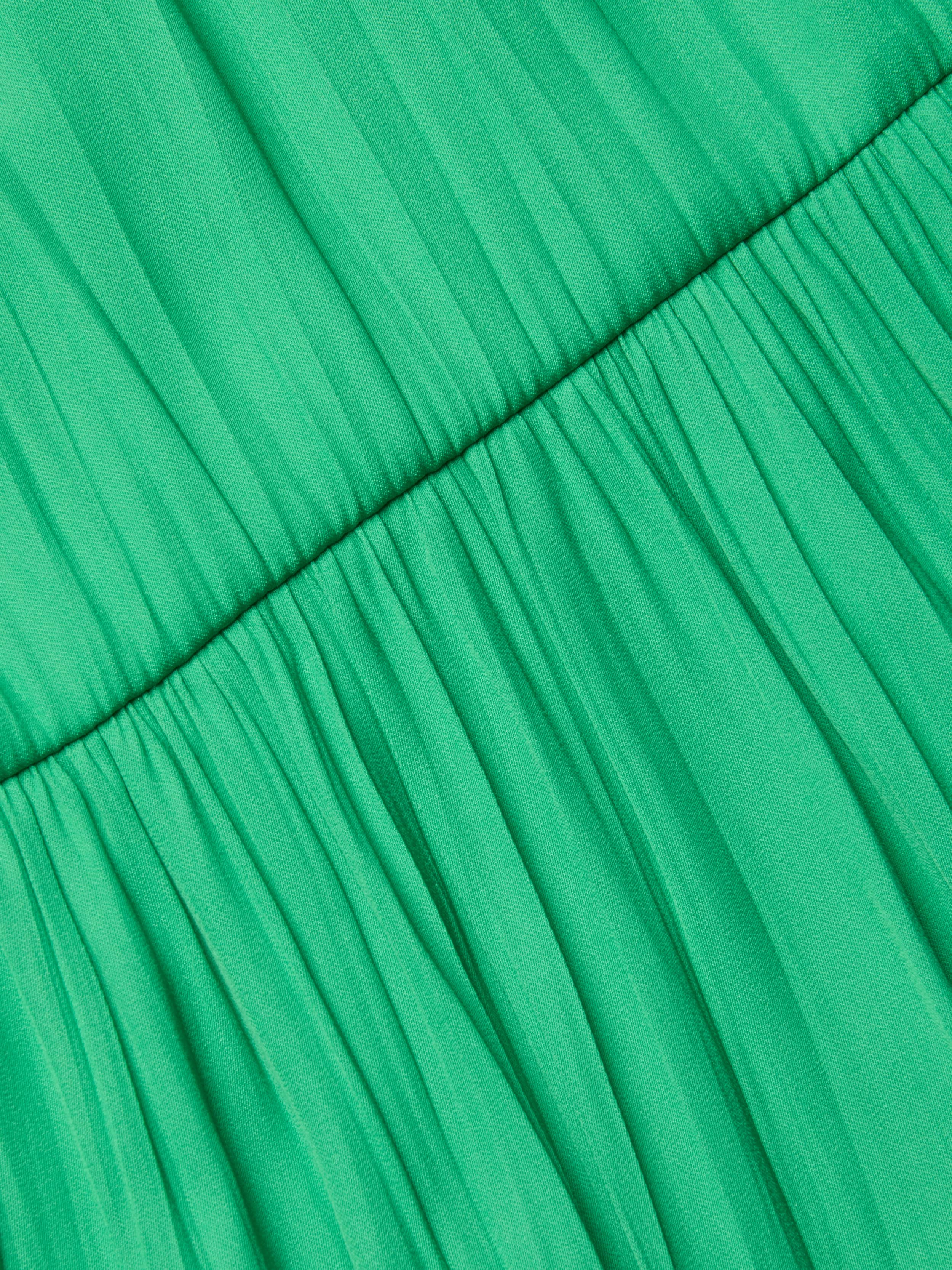 Close-up of the gathered green crinkle-effect satin fabric on the Lua Tiered Maxi Dress, featuring a horizontal seam that highlights its pleats and textured look.